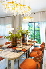 Beautiful luxurious traditional style modern dining room with bouquets of flowers on the table. Elegance dinning table with luxurious pendant.