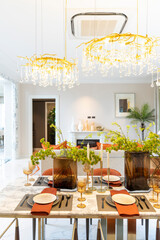 Beautiful luxurious traditional style modern dining room with bouquets of flowers on the table. Elegance dinning table with luxurious pendant.