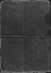 High-resolution scan of distressed black cardboard featuring deep fold marks and worn edges. The...