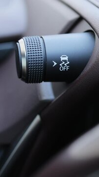 Vertical Video of ESP button electronic stability program control. Interior detail. The driver's finger presses the Traction Control System button on the car's dashboard. Traction Control System off