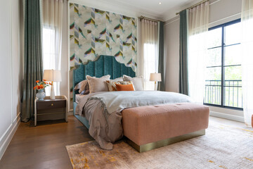 Interior view of luxury decorated green and blue bedroom with side table lamp and headboard.