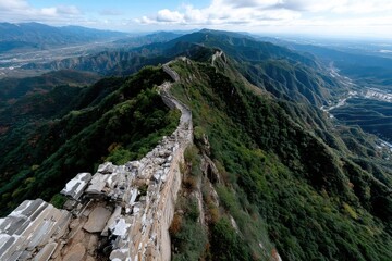 Fototapeta premium A breathtaking aerial view of the Great Wall sweeping across the majestic ridges of lush mountains, showcasing the harmony between ancient architecture and natural beauty.