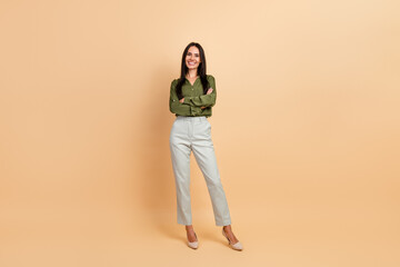 Confident female professional posing with a smile in formal attire against a beige background,...