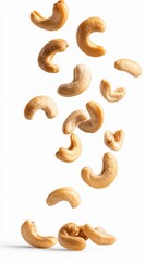 Individual Cashew Nuts Falling in Air Against White Background