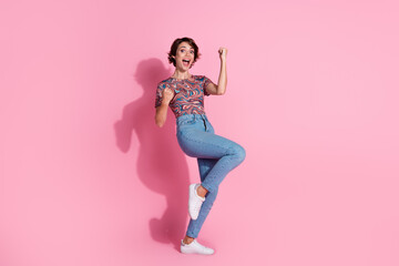 Photo of cheerful positive cute girl wear stylish clothes raise hands isolated on pink color...