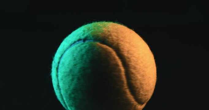 Close-up of a Tennis Ball under Studio Lighting. High-quality close-up shot of a tennis ball illuminated with dramatic studio lighting on a dark background. Sport, tennis, focus, competition, training