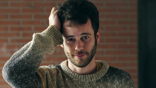 A puzzled young man gently scratches his head, showing uncertainty and confusion as he tries to remember something he might have forgotten