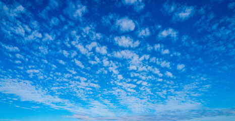 Bley sky and white clouds. Small clouds on blue sky. Beautiful sunny sky. Background with clouds on blue sky. Clouds overlay design.