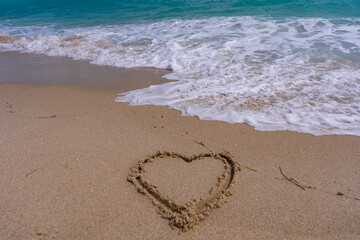 Sea beach sand. Scenic sea beach backdrop. Paradise ocean view. Heart drawn in sand. Waves forming a heart shape sign. Love on beach. Romantic summer. Heart made of sand. Love and ocean waves.