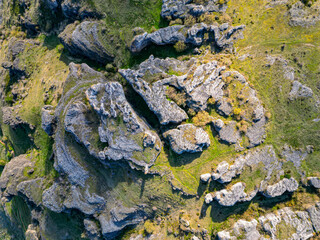 Drone photo showing abstract rock formations and green terrain from above. Natural landscape with geological textures and patterns, perfect for design or editorial use.