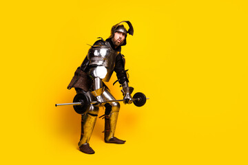 Naklejka premium Male knight lifting weights in medieval armor on a yellow background