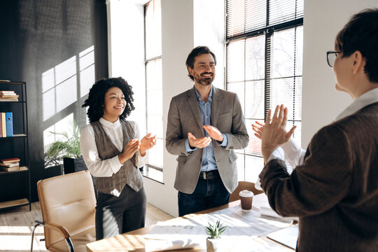 Business team applauding a colleague during a meeting in the office