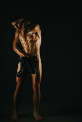 A contemplative male figure stands illuminated by soft light, emphasizing form and detail.