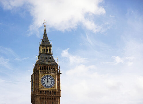 A view of the historic clocktower known as Big Ben and the Elizabeth Tower,  with the clock hands on 12 o'clock noon, Westminster, London. 