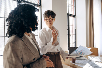 Businesswomen discussing graphs and financial reports in office