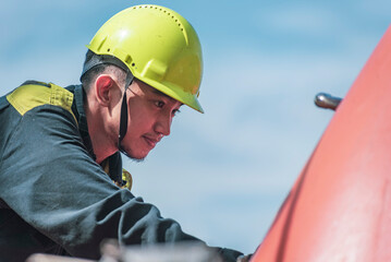 Portrait of the young Filipino officer, fully focused on his task during the inspection of the...