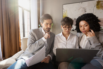 Fototapeta premium Business team analyzing data on laptop, evaluating project results in office