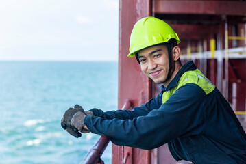 Portrait of a young Filipino officer in protective clothing and a yellow helmet, standing aboard a...