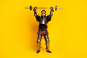 Naklejka premium Medieval knight in full armor lifting a barbell against a vibrant yellow background