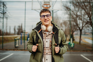 Fototapeta premium Portrait of a young man student smiling on a university basketball court 