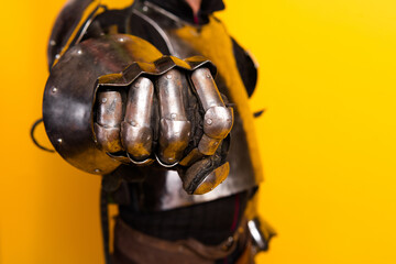 Close-Up of a Knight's Gauntlet in Armor Against a Bright Yellow Background Celebrating History