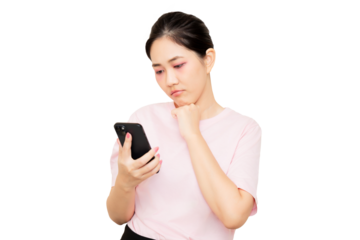 A thoughtful Asian woman in a pink shirt looks at her smartphone, contemplating something as she supports her chin with her hand.