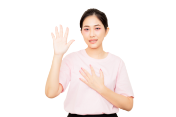 Asian young woman wearing a pink shirt and a glove raises one hand while placing the other on her chest, conveying a gesture of greeting or acknowledgment.