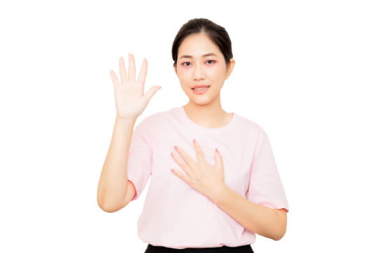 Asian young woman wearing a pink shirt and a glove raises one hand while placing the other on her chest, conveying a gesture of greeting or acknowledgment.