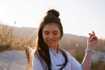 Joyful young woman in nature during sunset - ideal for casual lifestyle and relaxation themes