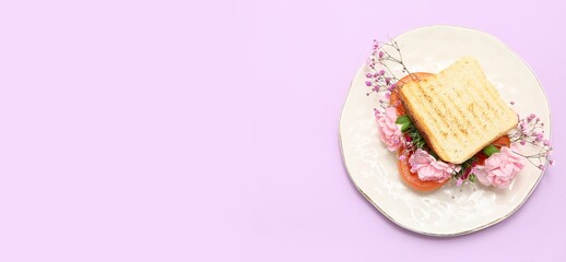 Sandwich with beautiful flowers on lilac background with space for text, top view