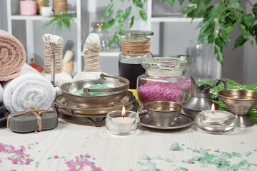 Spa treatment with candles and towel on wooden table, close up