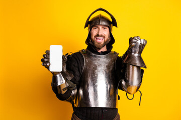 Medieval knight showcasing a smartphone against a bright yellow background