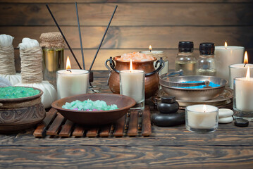 Spa treatment with candles and towel on wooden table, closeup