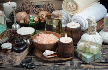 Spa treatment with candles and towel on wooden table, closeup