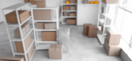 Blurred view of warehouse with shelf units and cardboard boxes