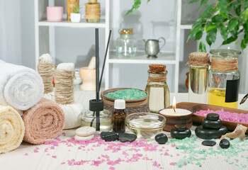 Spa treatment with candles and towel on wooden table, closeup
