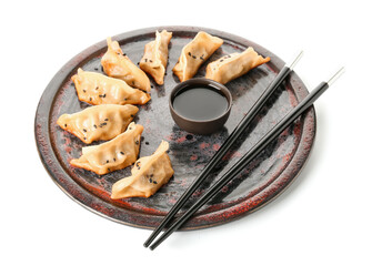 Plate with tasty Chinese jiaozi and sauce on white background
