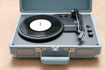 Obraz premium Record player with vinyl disk on beige background, closeup