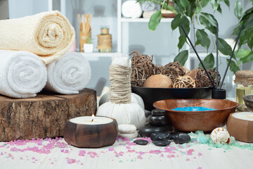 Spa treatment with candles and towel on wooden table, closeup