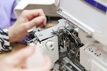 A female mechanic cleans and oils a sewing machine.