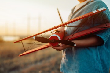 Close-up hands of child Boy holds Craft Wooden Retro Styled Airplane. Traveling