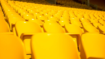Fototapeta premium Rows of Empty Yellow Stadium Seats Highlighting Minimalist Design and Vibrant Colors in an Open-Air Venue