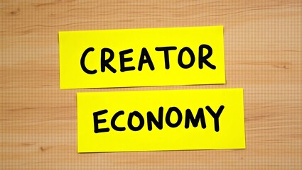 The rise of the creator economy, a bold new landscape for independent artists and entrepreneurs, captured in simple yellow sticky notes on a warm wooden background.