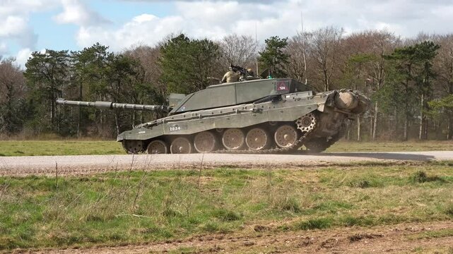 a British army Challenger 2 II FV4034 main battle tank traversing a country track, in action on a military exercise