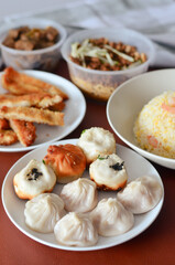 Pan-Fried Chinese Buns Surrounded by Traditional Chinese Dishes