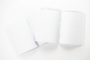 Open notebooks in ruler on white background.