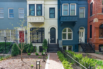 View of a colonial row house, townhouse, with a colorful, brick facade on a quiet street in Washington, D.C., USA