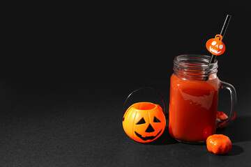 Pumpkins with glass of delicious bloody Mary cocktail for Halloween celebration on black background