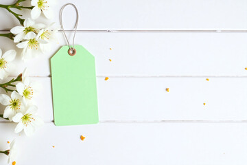 green tag with white flowers on a wooden table