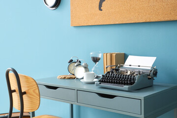 Vintage typewriter with coffee cup, alarm clocks and books on table in office